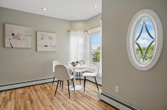 dining room with light wood-style flooring, a baseboard radiator, and recessed lighting