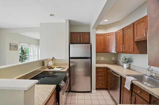 kitchen featuring appliances with stainless steel finishes, a sink, light countertops, light tile patterned floors, and recessed lighting