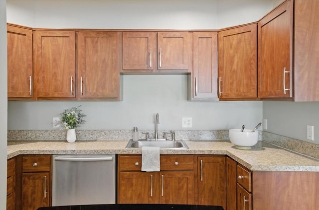 kitchen featuring stainless steel dishwasher, a sink, light countertops, and brown cabinetry
