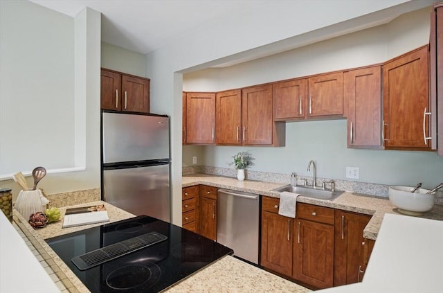 kitchen featuring stainless steel appliances, a sink, and brown cabinets