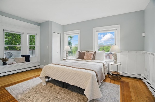 bedroom featuring baseboard heating and wood finished floors