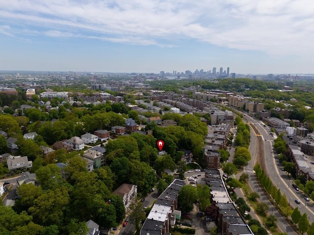 aerial view of property's location with nearby urban area and a tree filled landscape