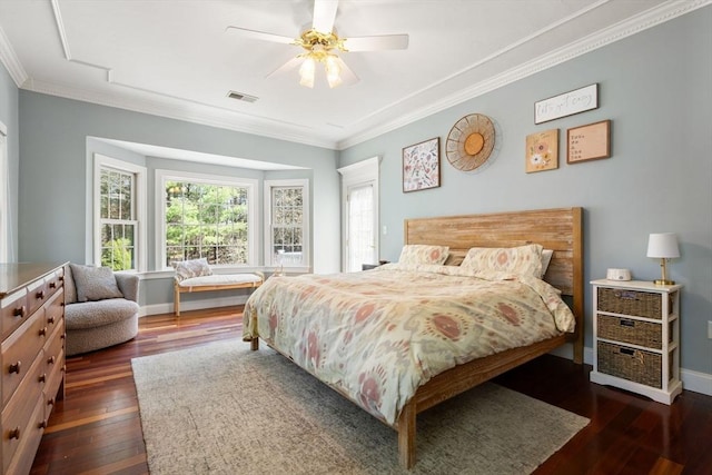 bedroom featuring dark wood-type flooring, ornamental molding, baseboards, and visible vents