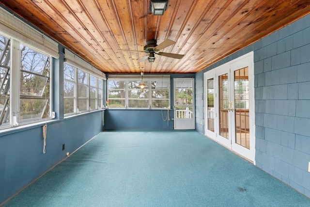 unfurnished sunroom featuring ceiling fan, french doors, and a healthy amount of sunlight