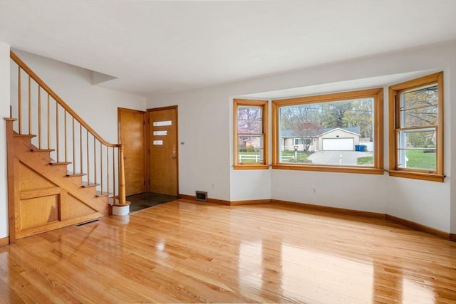 entryway with visible vents, light wood-type flooring, and stairs