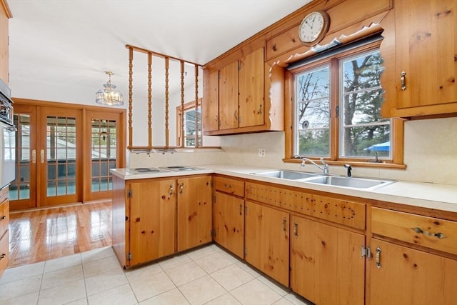 kitchen featuring an inviting chandelier, a sink, a wealth of natural light, and light countertops