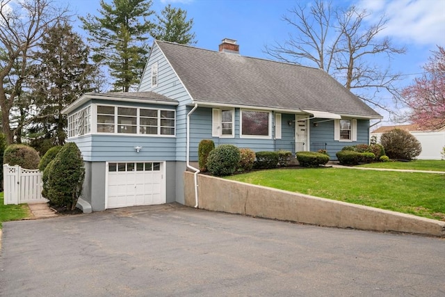 view of front of house featuring aphalt driveway, a chimney, a gate, roof with shingles, and a garage