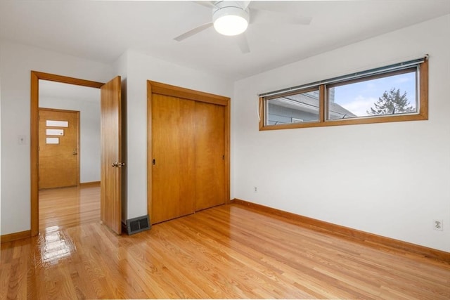 unfurnished bedroom featuring visible vents, light wood-type flooring, baseboards, and a closet