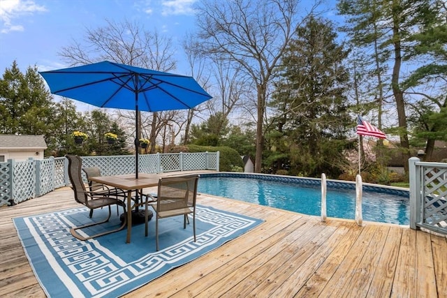 pool with a deck and outdoor dining area