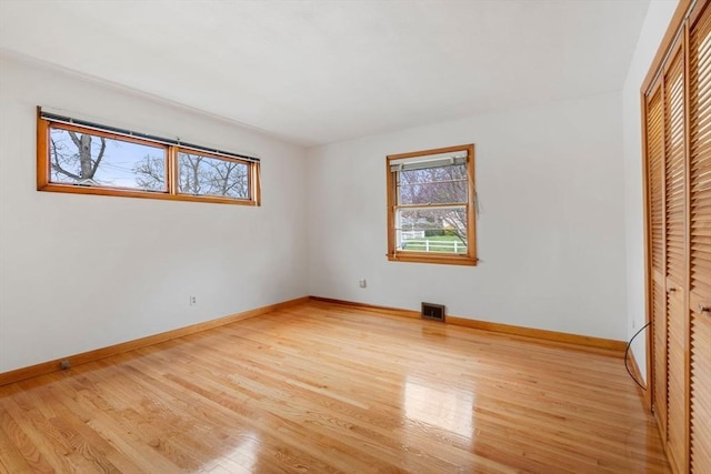 unfurnished bedroom with baseboards and light wood-style flooring