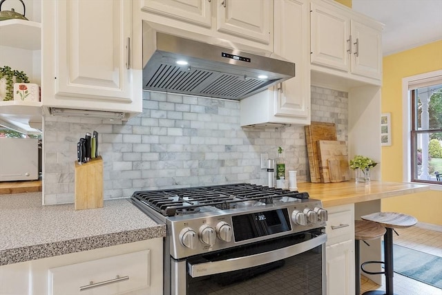 102 Chestnut St, Andover, MA 01810 - kitchen featuring stainless steel range with gas cooktop, ventilation hood, decorative backsplash, and white cabinetry