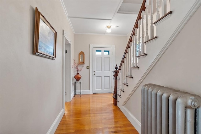 102 Chestnut St, Andover, MA 01810 - entrance foyer featuring radiator heating unit, light wood finished floors, baseboards, crown molding, and stairs