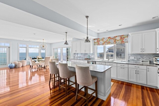 55 Seaside Rd, Scituate, MA 02066 - kitchen with tasteful backsplash, hardwood / wood-style flooring, a kitchen breakfast bar, and recessed lighting