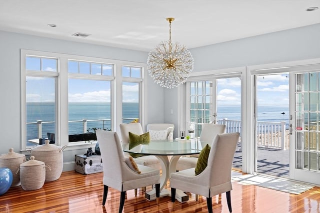 55 Seaside Rd, Scituate, MA 02066 - dining area with a water view, wood finished floors, a chandelier, plenty of natural light, and recessed lighting