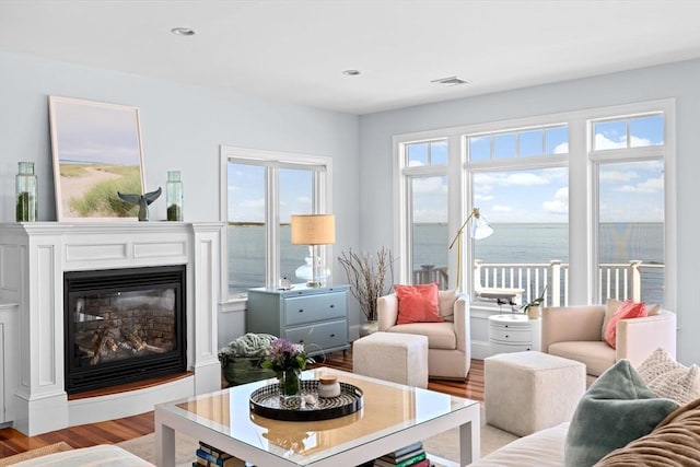 55 Seaside Rd, Scituate, MA 02066 - living area featuring light wood finished floors, a glass covered fireplace, recessed lighting, and a water view