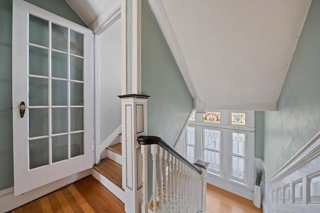 staircase featuring french doors, wood finished floors, and vaulted ceiling