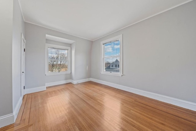 unfurnished room with light wood finished floors, baseboards, and ornamental molding