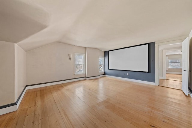 bonus room featuring plenty of natural light, light wood-style flooring, baseboards, and lofted ceiling