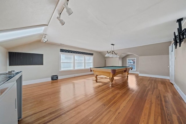 game room with vaulted ceiling, baseboards, arched walkways, and light wood finished floors