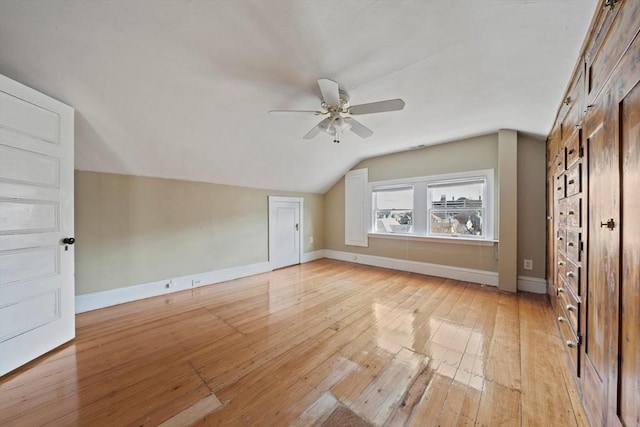 bonus room featuring a ceiling fan, lofted ceiling, baseboards, and light wood-type flooring