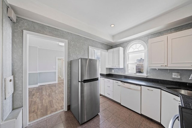 kitchen featuring freestanding refrigerator, white dishwasher, granite finish floor, white cabinets, and a sink