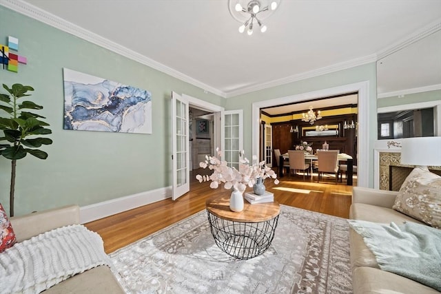 living room with a chandelier, crown molding, and wood finished floors