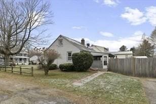 view of home's exterior featuring a lawn and fence