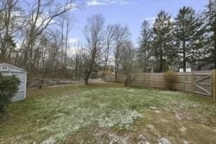 view of yard with an outbuilding, a storage unit, and a fenced backyard