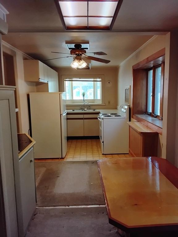 kitchen with crown molding, white cabinets, a sink, ceiling fan, and white appliances