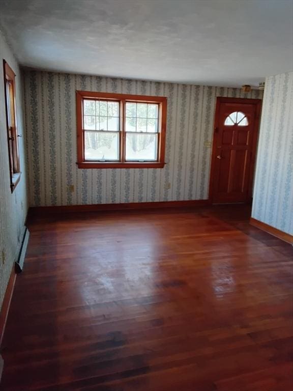 entryway featuring dark wood-style floors, baseboards, and wallpapered walls