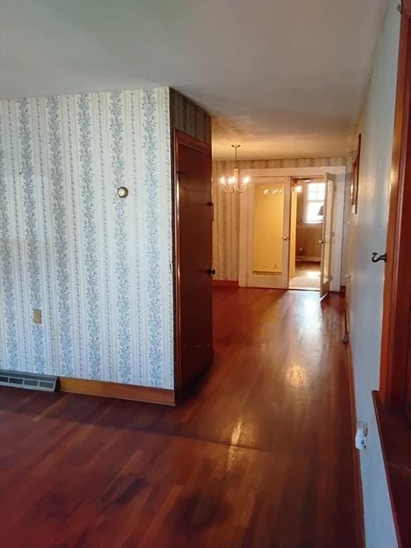 hallway featuring visible vents, a chandelier, and dark wood-style flooring