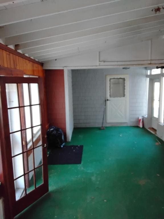 interior space featuring french doors and vaulted ceiling with beams