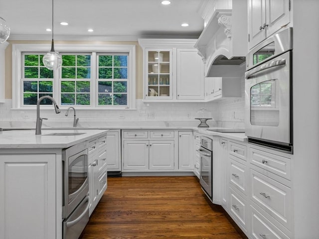 50 Temple Rd, Wellesley, MA 02482 - kitchen featuring oven, a sink, white cabinetry, tasteful backsplash, and crown molding