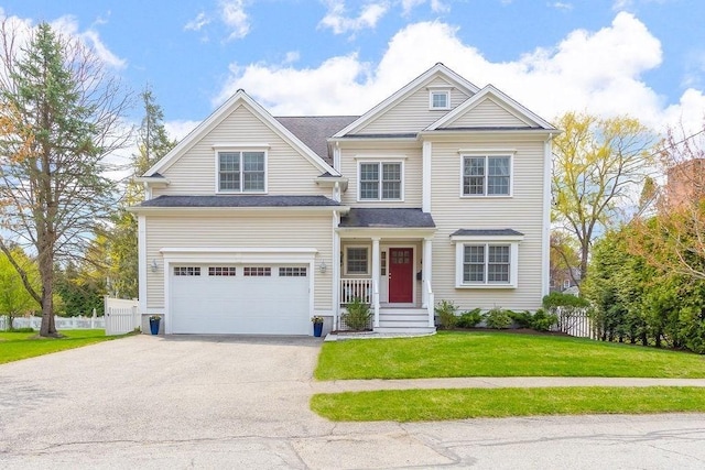 craftsman inspired home with an attached garage, fence, driveway, and a front lawn