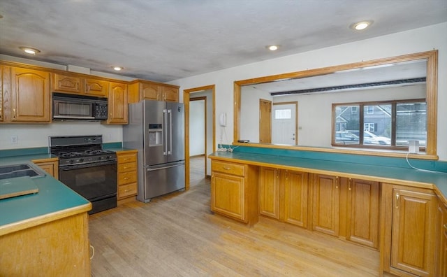 kitchen with black appliances, brown cabinetry, recessed lighting, and light wood-style floors