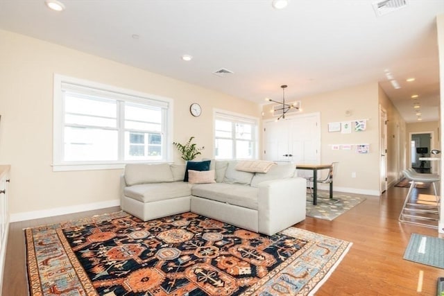 living area featuring light wood-style flooring, recessed lighting, baseboards, and visible vents