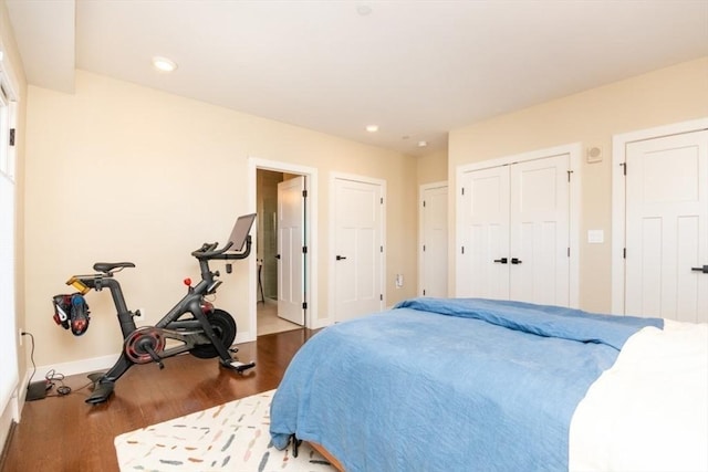 bedroom with ensuite bath, recessed lighting, wood finished floors, and baseboards