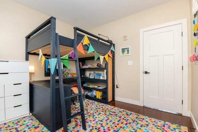 bedroom with baseboards and wood finished floors