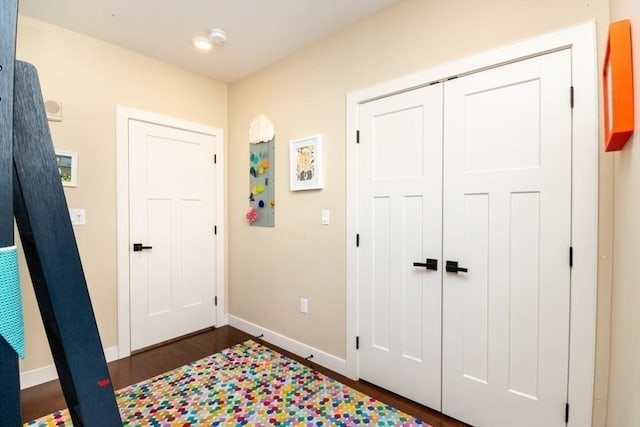 foyer with dark wood finished floors and baseboards