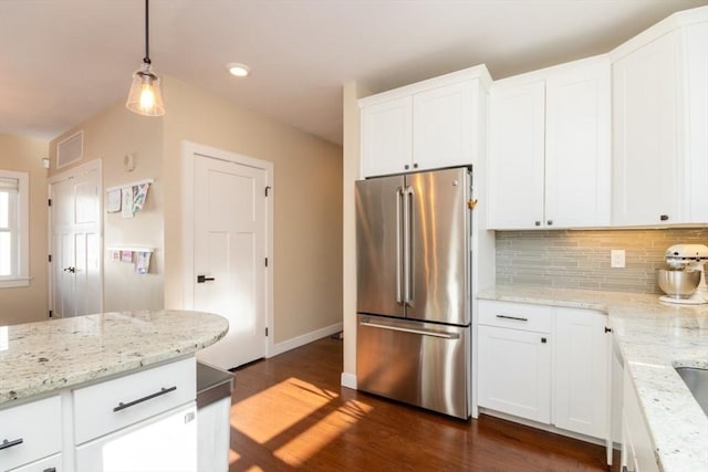 kitchen with high end fridge, dark wood-style flooring, white cabinets, decorative light fixtures, and tasteful backsplash