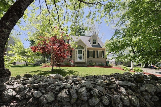 cape cod house featuring a front lawn and entry steps