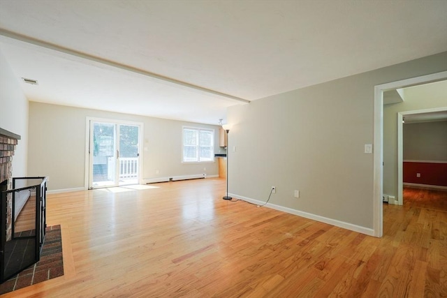 unfurnished living room with light wood-style flooring, a fireplace, baseboards, and baseboard heating