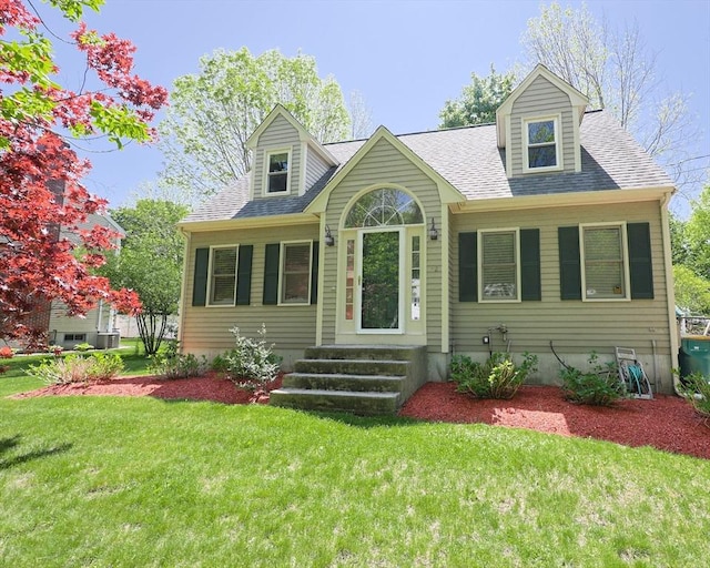 cape cod home with a front lawn and roof with shingles