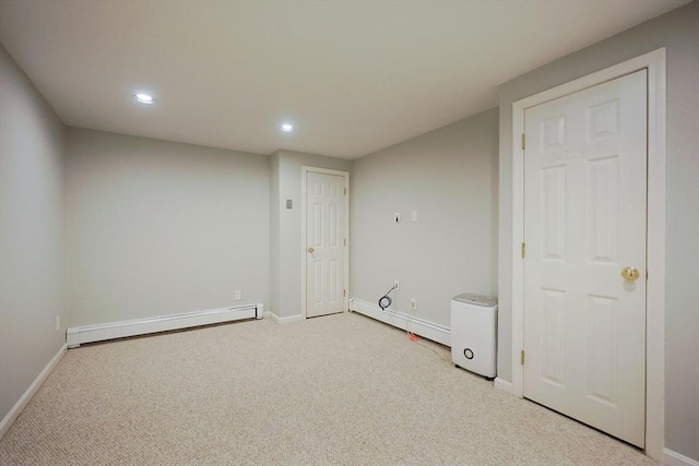 unfurnished room with a baseboard radiator, light colored carpet, recessed lighting, and baseboards