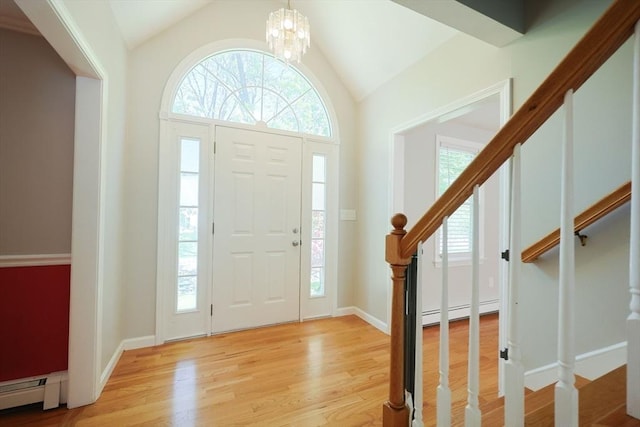 entryway with a baseboard radiator, lofted ceiling, stairway, light wood-type flooring, and a chandelier