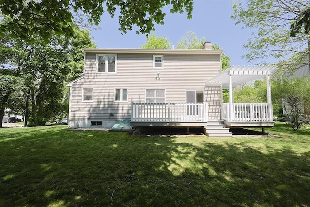 back of house featuring a chimney, a pergola, a deck, and a yard