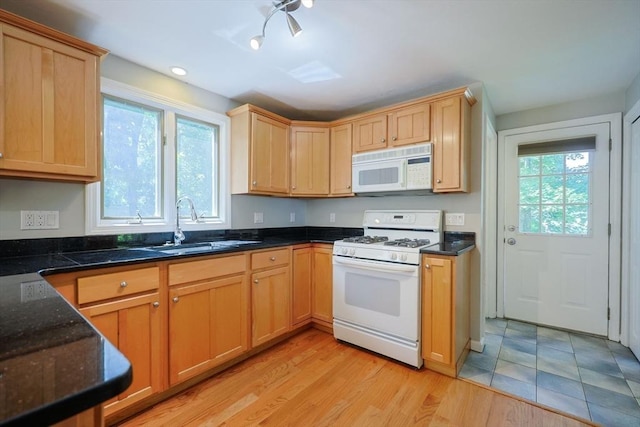 kitchen featuring white appliances, a sink, and light brown cabinets