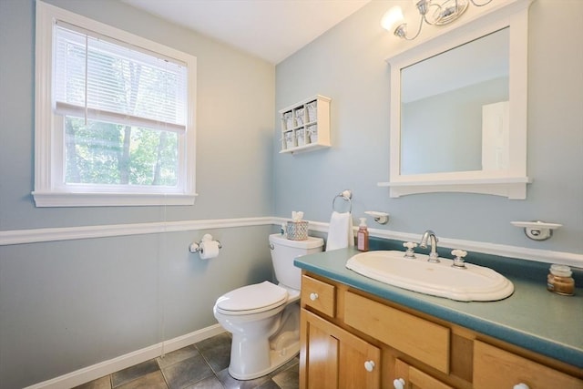 bathroom with toilet, baseboards, and vanity