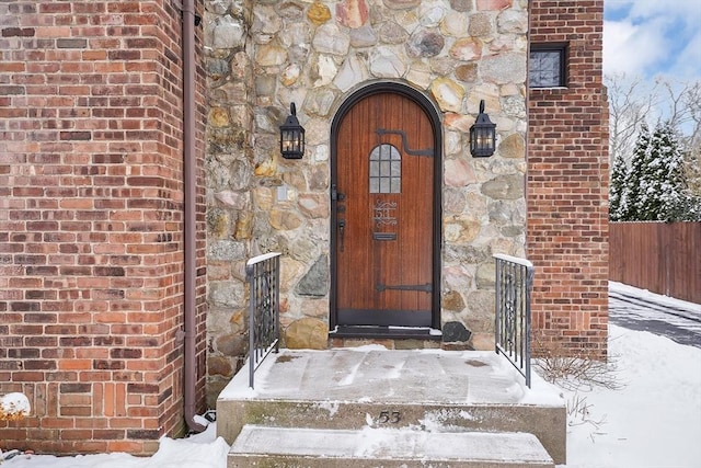 property entrance with stone siding and brick siding