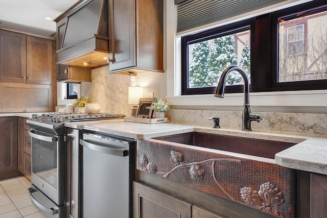 kitchen featuring appliances with stainless steel finishes, light stone countertops, custom range hood, and light tile patterned floors